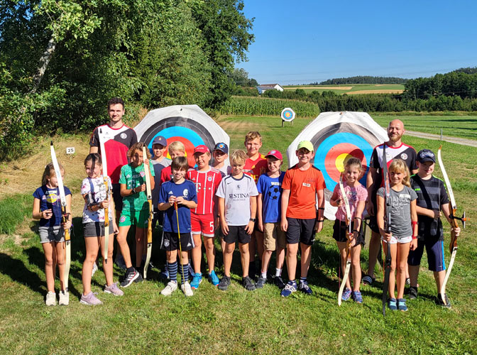Kinder des Ferienprogramms posieren vor den Zielscheiben der Bogenschützen