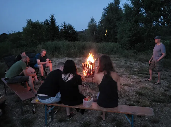 Personen um das Sonnwendfeuer am Vereinsheim